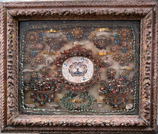 Reliquaire à papiers roulés XVIIe : Miniature symbolique Agnus Dei surmontant un calice dans un décor de papiers roulés Reliquaire à papiers roulés XVIIe : Miniature symbolique Agnus Dei surmontant un calice dans un décor de papiers roulés